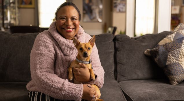 Woman sitting on a couch holding her dog