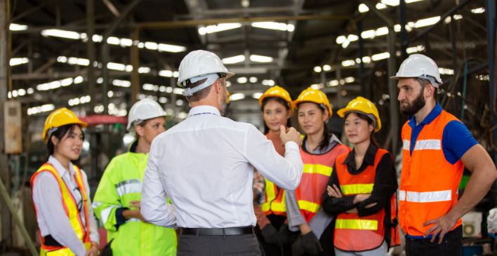 Group of workers in a warehouse speaking to their supervisor