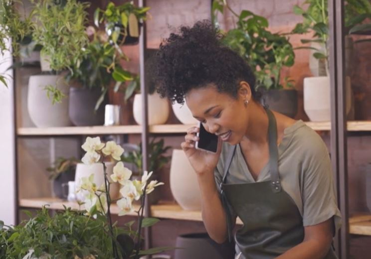 Woman in florist shop talking on mobile phone